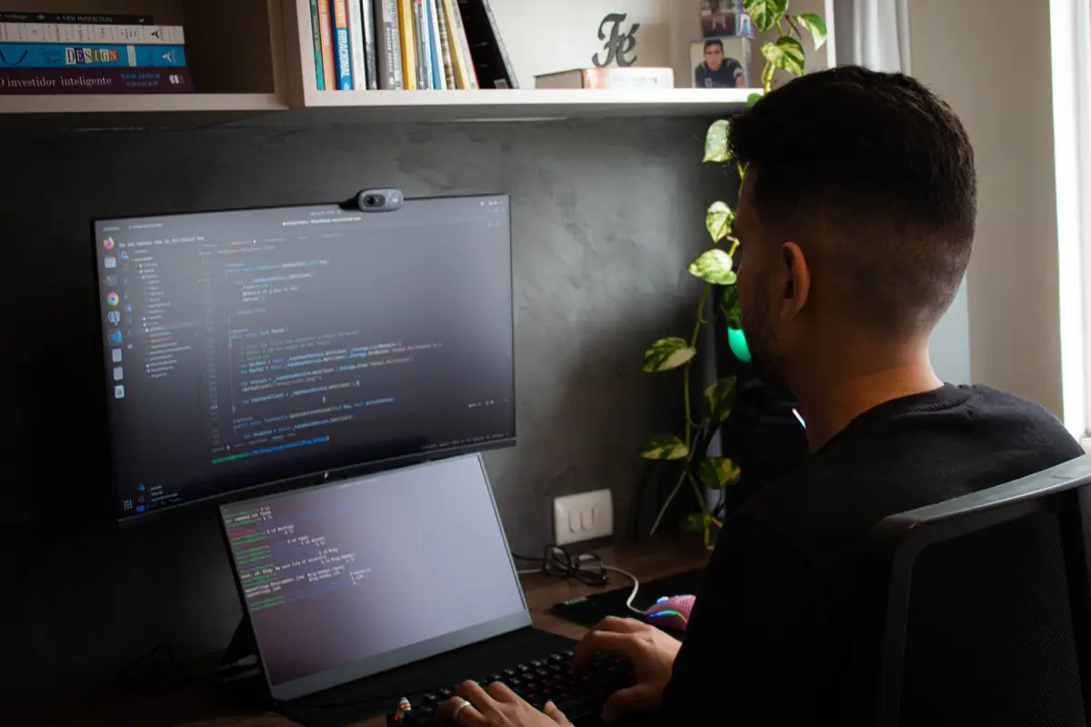 Programmer working on a laptop and external monitor